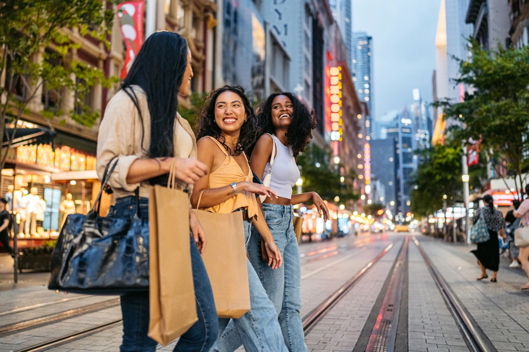 Man in plaid shirt using chainsaw to cut tree branches outdoors.